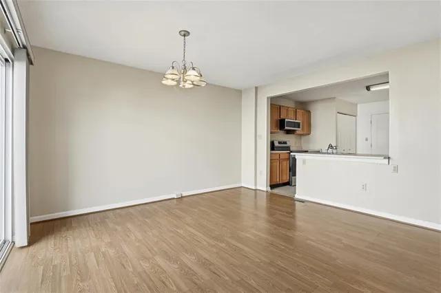 a view of a kitchen with a sink wooden cabinets and a refrigerator