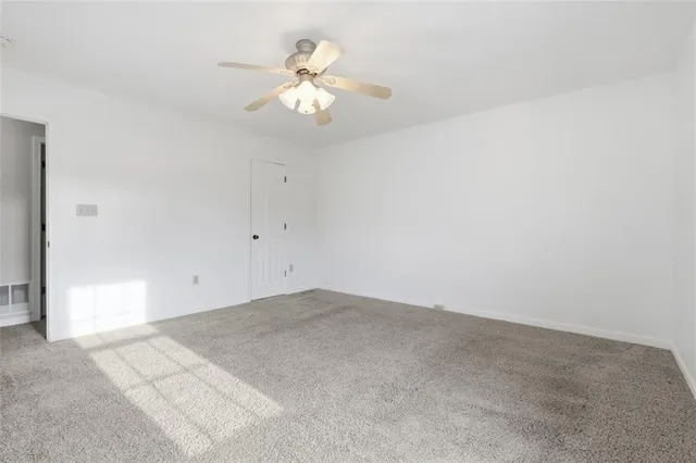 an empty room with a chandelier fan
