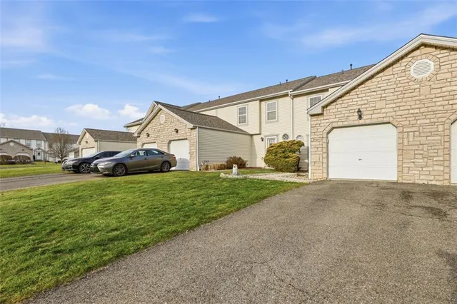 a view of a white house with a big yard and large trees