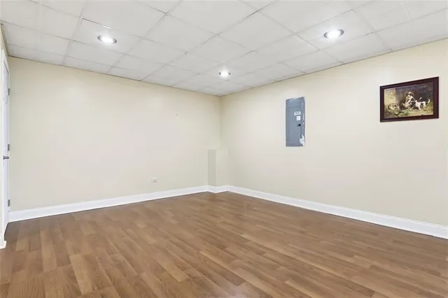 an empty room with wooden floor and a ceiling fan