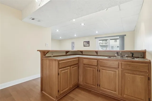 a kitchen with sink a mirror and cabinets