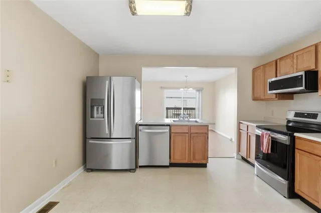 a kitchen with stainless steel appliances granite countertop a refrigerator stove a sink and a microwave