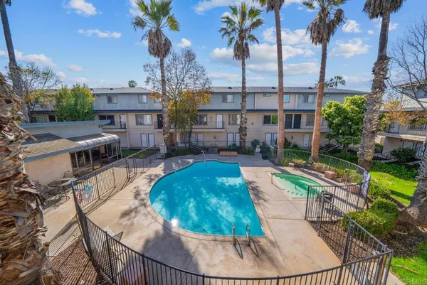 a view of a swimming pool with a patio and a yard