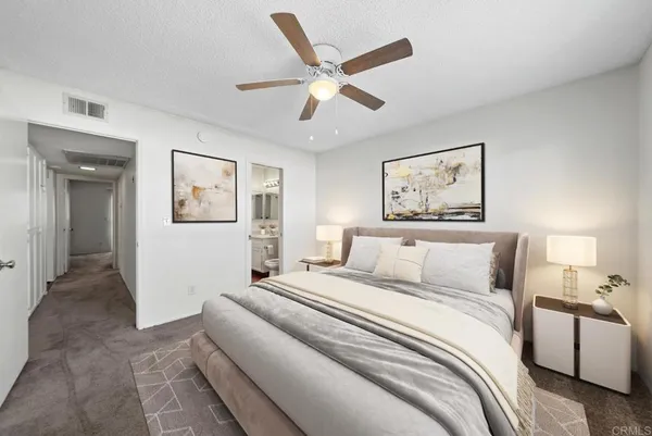 a bedroom with a large bed and a chandelier