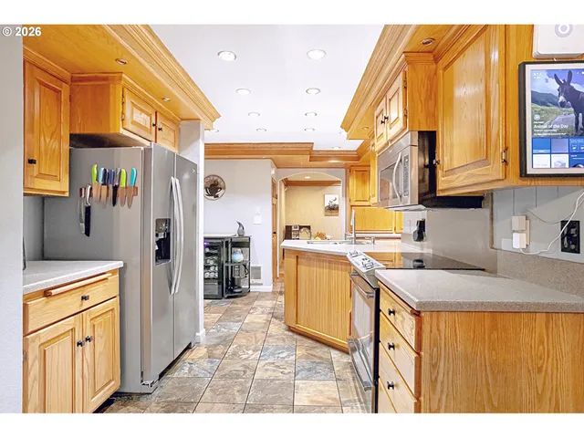 a kitchen that has a lot of cabinets in it and wooden floors