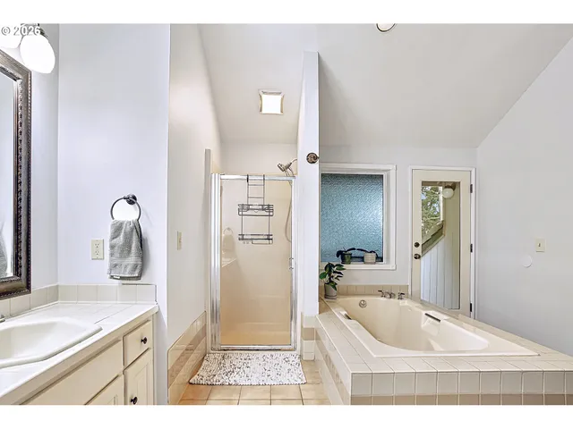 a bathroom with a granite countertop sink a large mirror and a bathtub