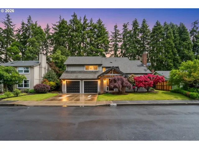 a front view of a house with a yard and trees