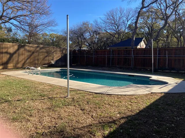 a backyard of a house with lots of green space and wooden fence