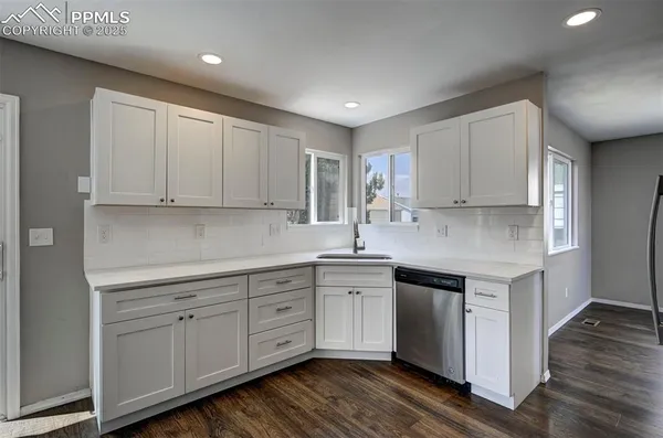 a kitchen with a sink cabinets and wooden floor