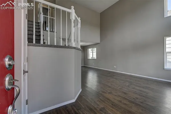 an entryway with wooden floor and windows