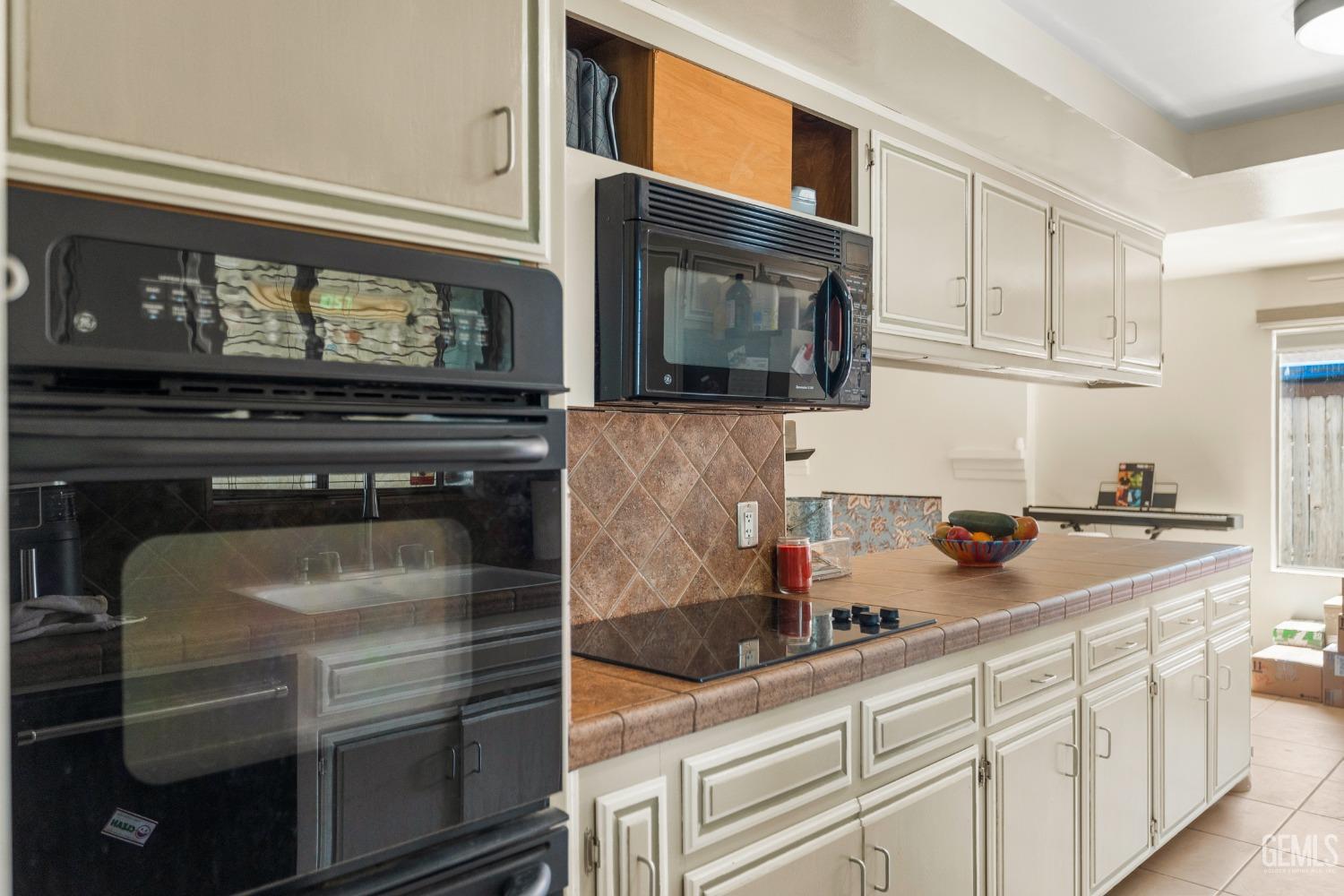 Undisclosed Address Bakersfield, CA 93313 - Photo 11 of 24 a kitchen with granite countertop a stove and cabinets