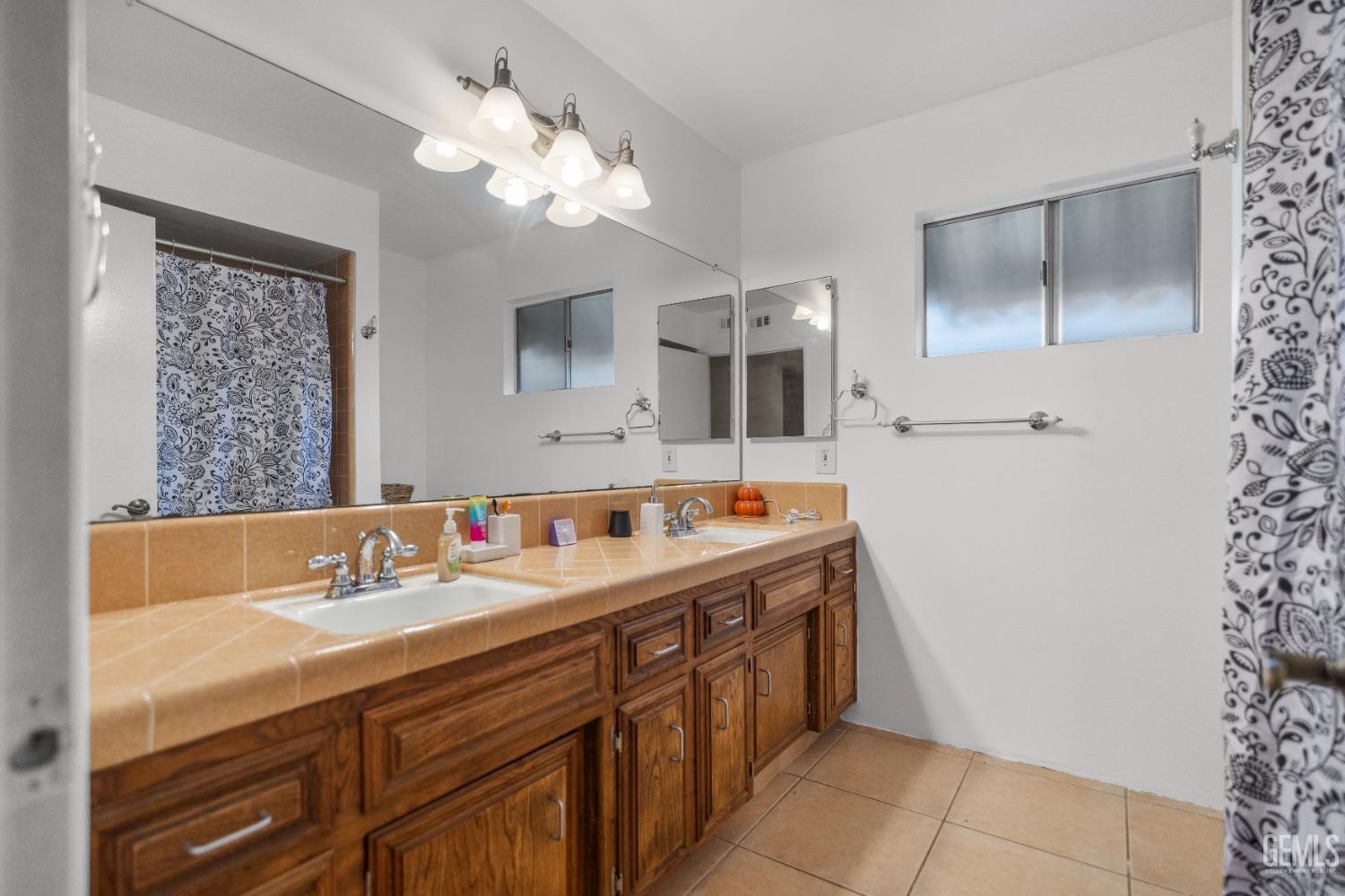Undisclosed Address Bakersfield, CA 93313 - Photo 13 of 24 a bathroom with a sink double vanity and a mirror