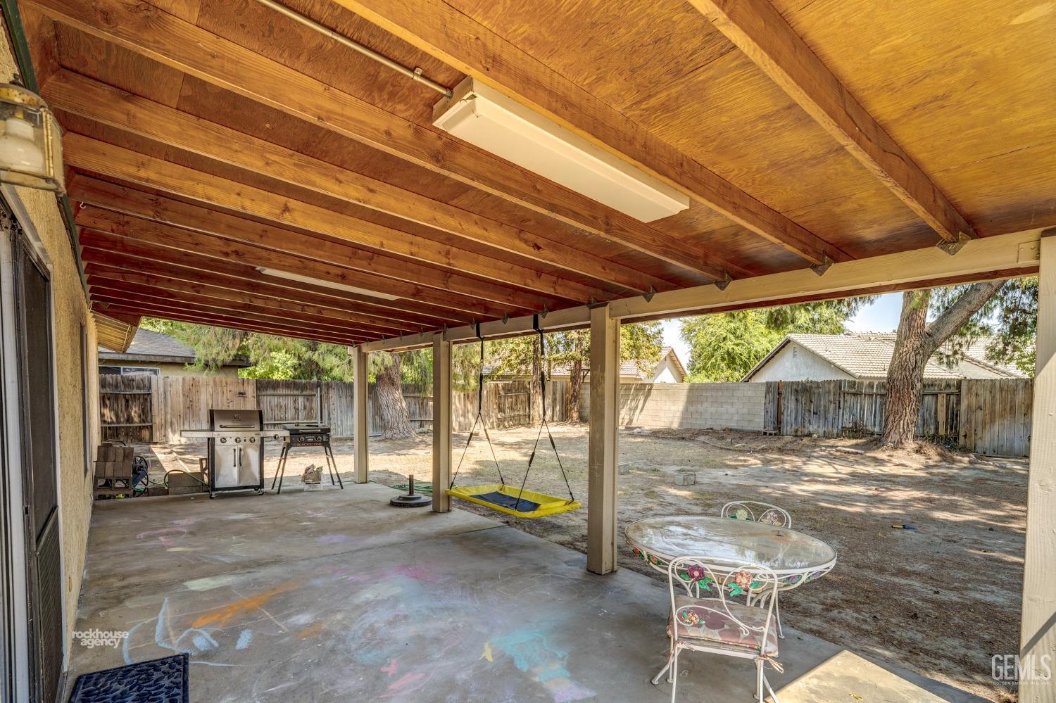 Undisclosed Address Bakersfield, CA 93313 - Photo 19 of 24 a view of a patio with table and chairs and couches with wooden fence