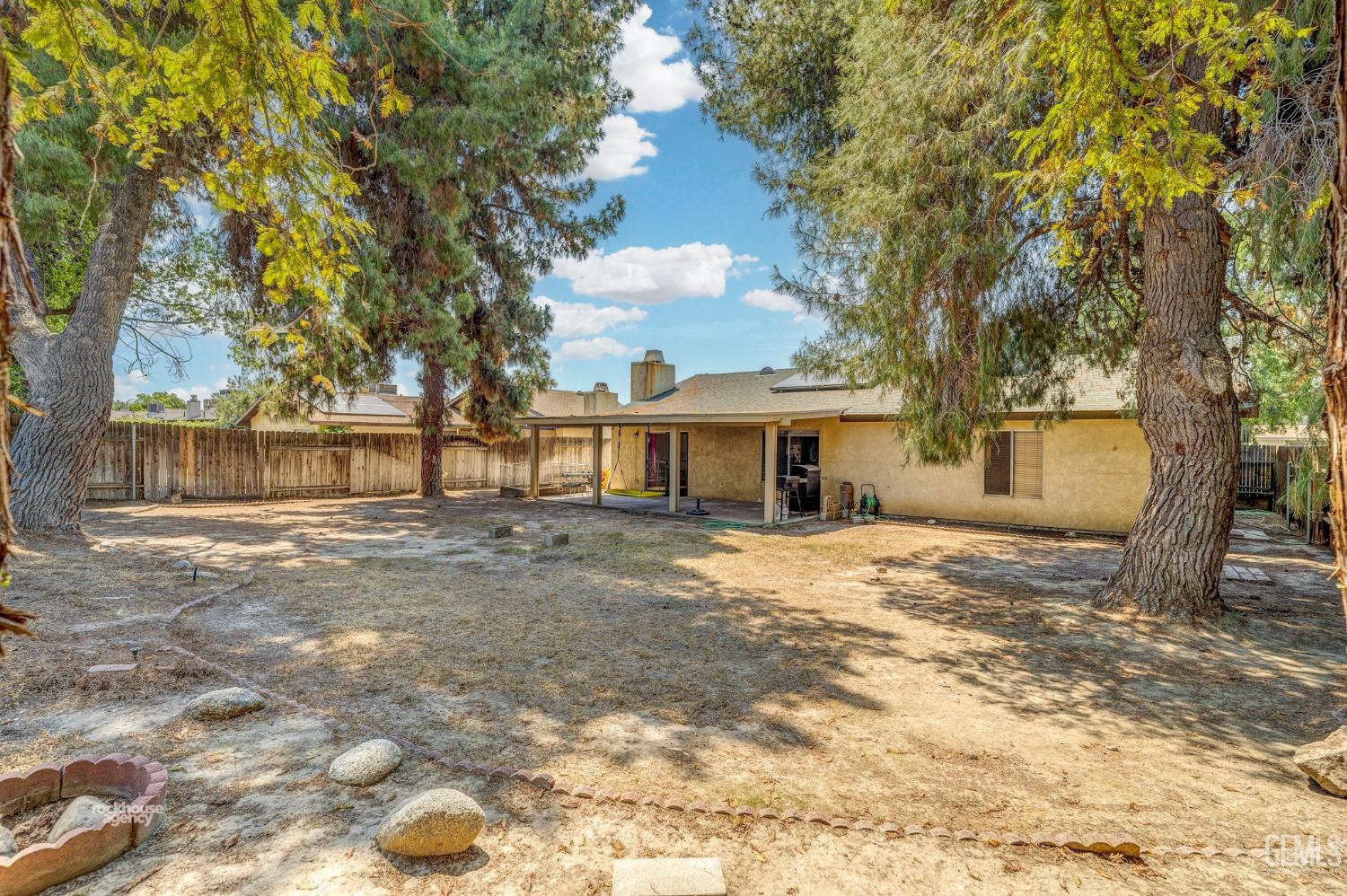 Undisclosed Address Bakersfield, CA 93313 - Photo 22 of 24 a front view of a house with a yard and trees