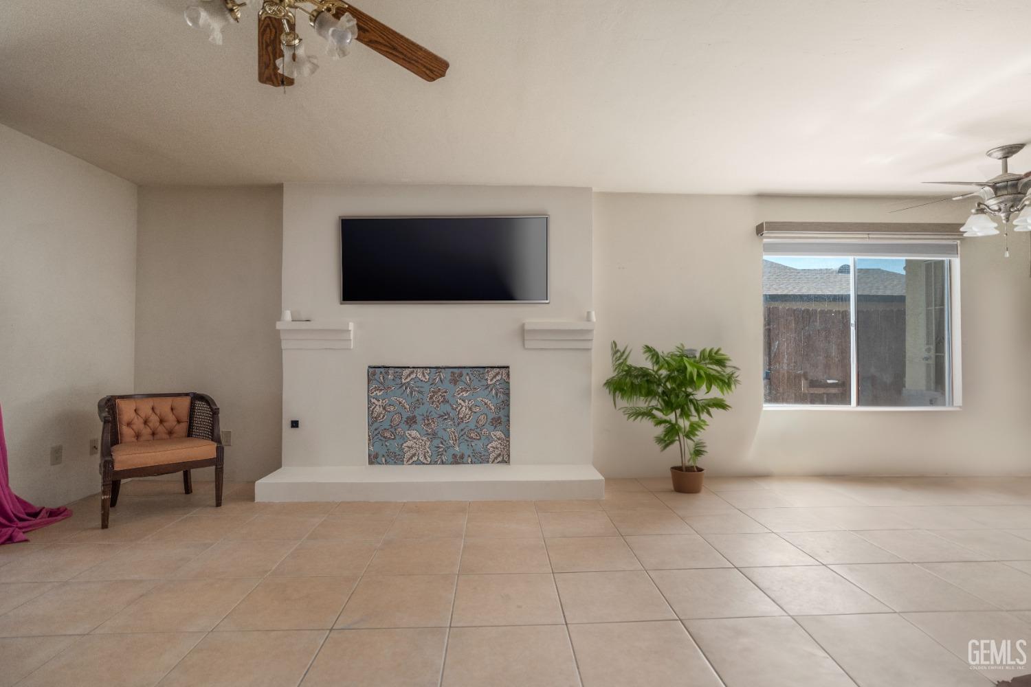 Undisclosed Address Bakersfield, CA 93313 - Photo 7 of 24 a living room with furniture a flat screen tv and a fireplace