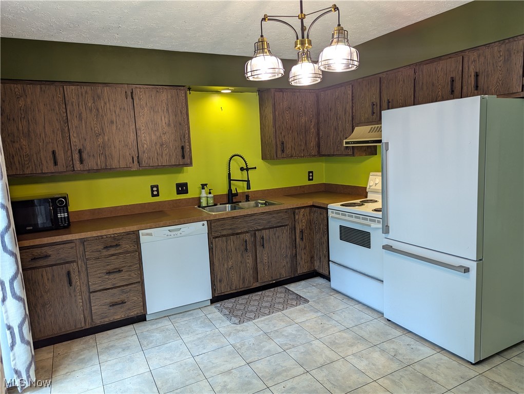 2500 Cleveland Road, Unit 202 Wooster, OH 44691 - Photo 3 of 22 Kitchen featuring light tile patterned flooring, hanging light fixtures, white appliances, sink, and a textured ceiling