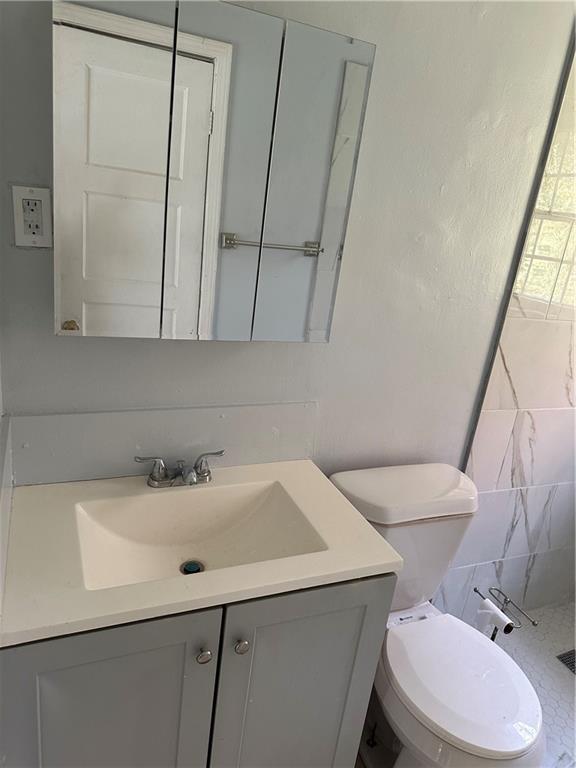 2647 Baker Ridge Drive Northwest Atlanta, GA 30318 - Photo 18 of 39 a bathroom with a sink a toilet and a mirror