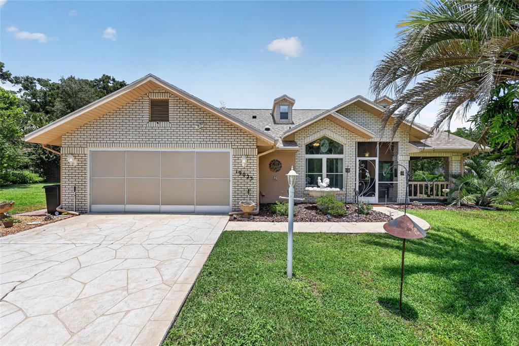 19025 Southwest 98th Loop Dunnellon, FL 34432 - Photo 8 of 80 a front view of a house with a yard and garage