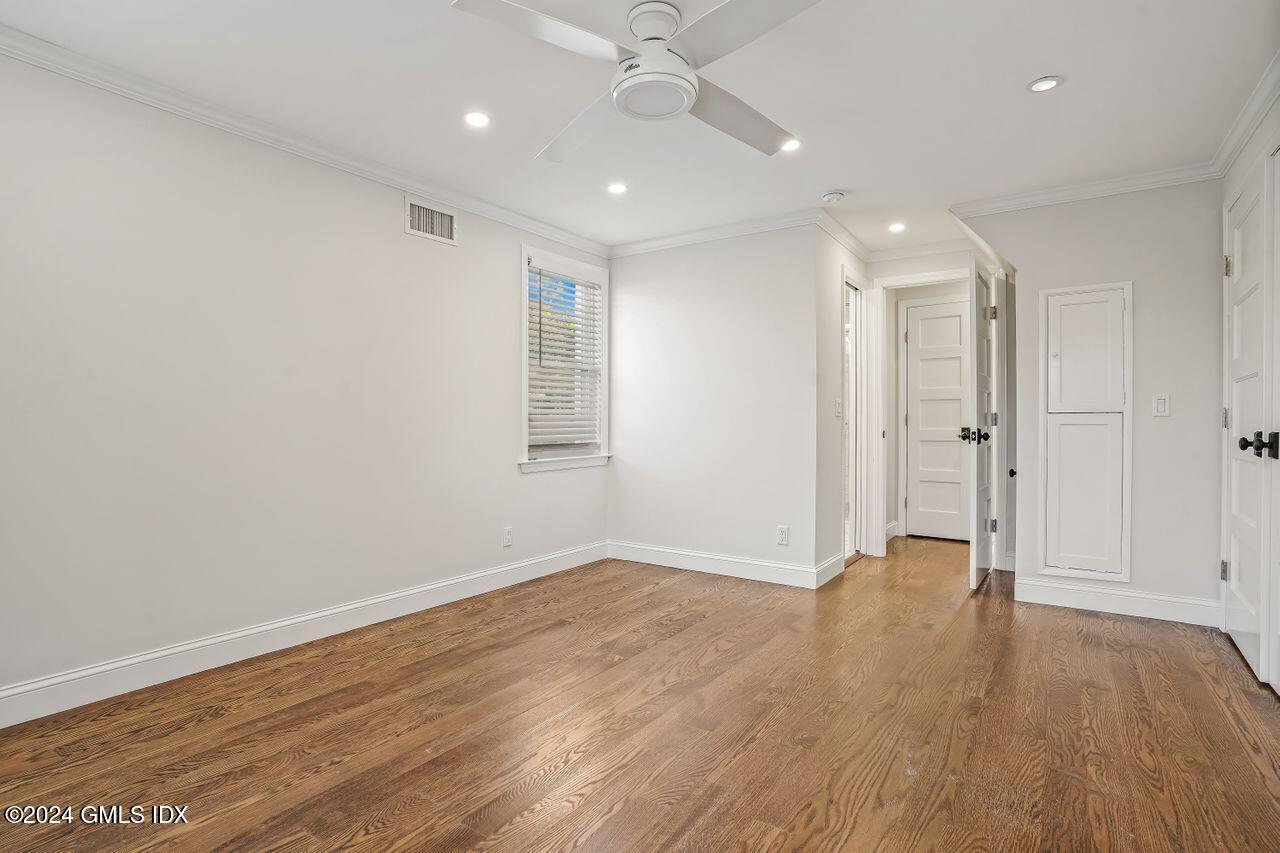 52 Le Grande Avenue, Unit 2 Greenwich, CT 06830 - Photo 12 of 31 an empty room with wooden floor and windows