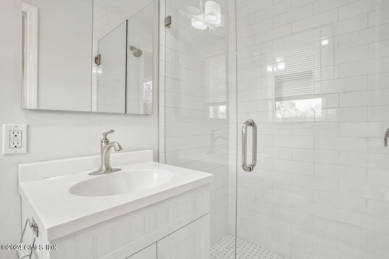 52 Le Grande Avenue, Unit 2 Greenwich, CT 06830 - Photo 8 of 31 a bathroom with a sink shower and a mirror