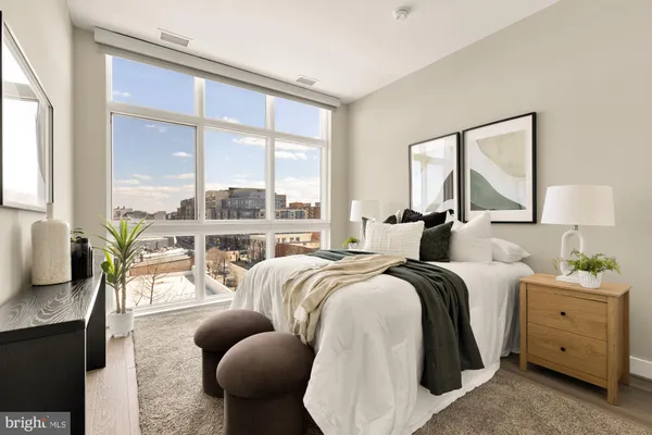 a bedroom with furniture and a large window