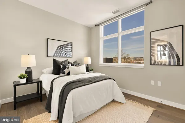 a bedroom with a bed and a painting on the wall