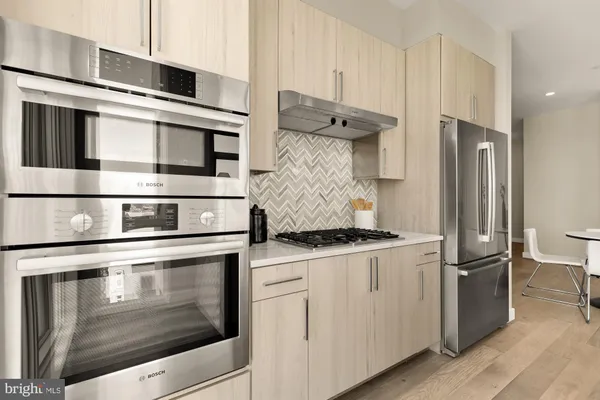a kitchen with stainless steel appliances granite countertop a stove and a refrigerator