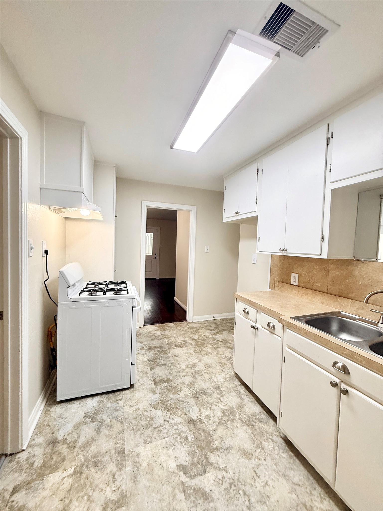 1232 San Felipe Street Angleton, TX 77515 - Photo 4 of 16 a kitchen with a stove a sink and a refrigerator