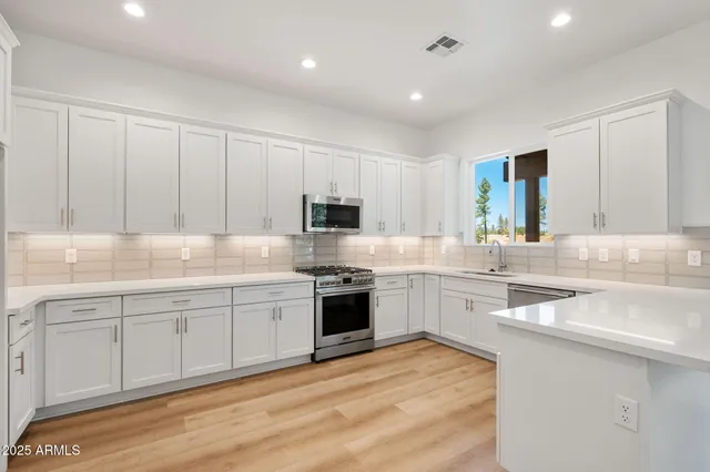 a kitchen with granite countertop white cabinets and white appliances