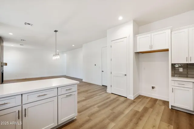 a kitchen with a refrigerator and white cabinets