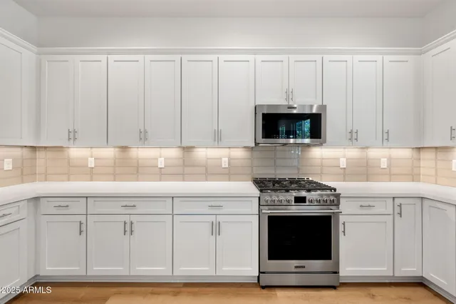 a kitchen with white cabinets and appliances