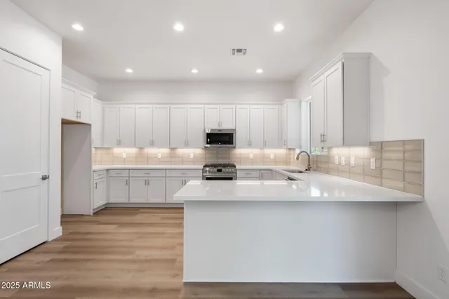 a kitchen with stainless steel appliances granite countertop a sink a stove and a refrigerator