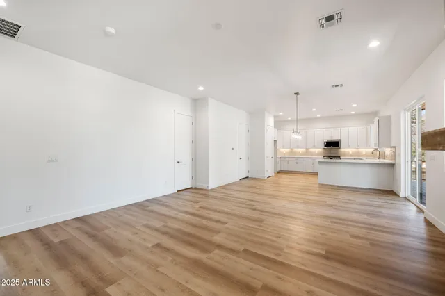 a large kitchen with kitchen island a sink stainless steel appliances and cabinets