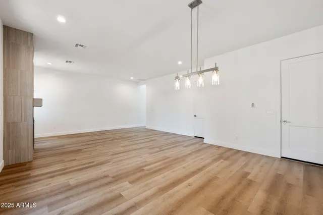 a view of empty room with wooden floor and ceiling fan