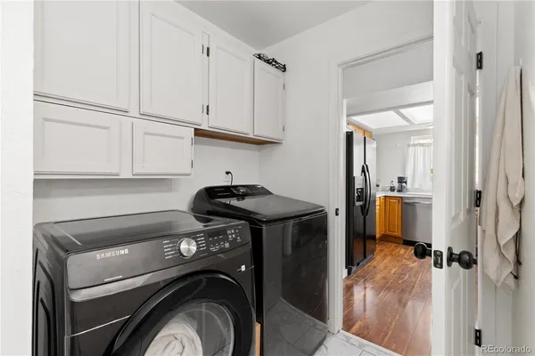 a view of washer and dryer with kitchen in the background