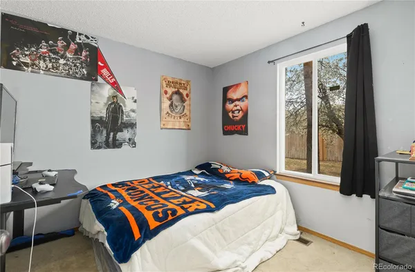 a bedroom with a bed and a painting on the wall