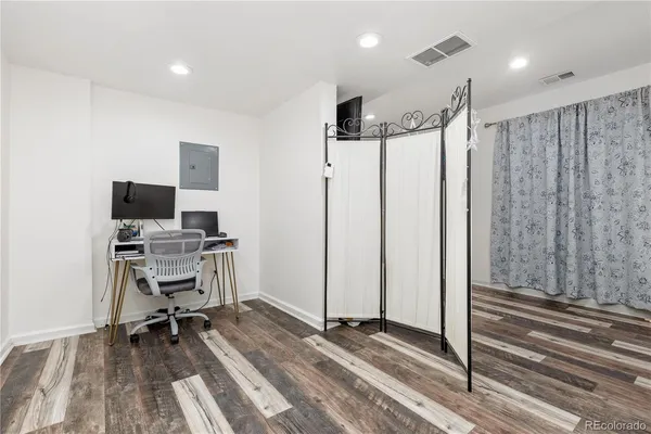 a view of a workspace with furniture and wooden floor
