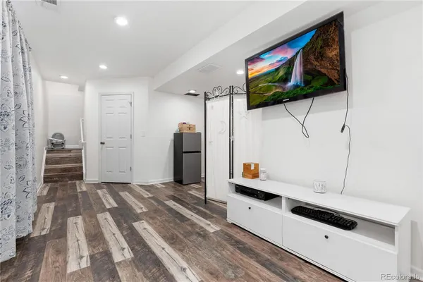 a kitchen with stainless steel appliances white cabinets and wooden floor