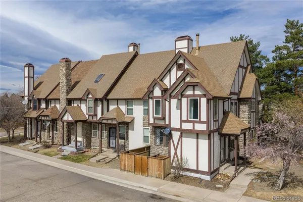 a view of a big house with wooden fence