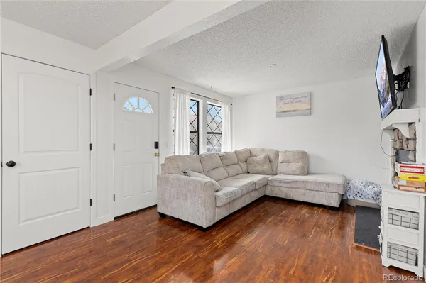 a living room with furniture and a wooden floor