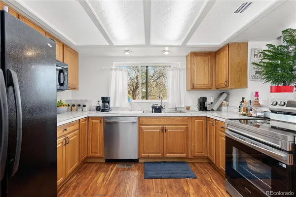 a kitchen with stainless steel appliances granite countertop a stove a sink dishwasher and a refrigerator