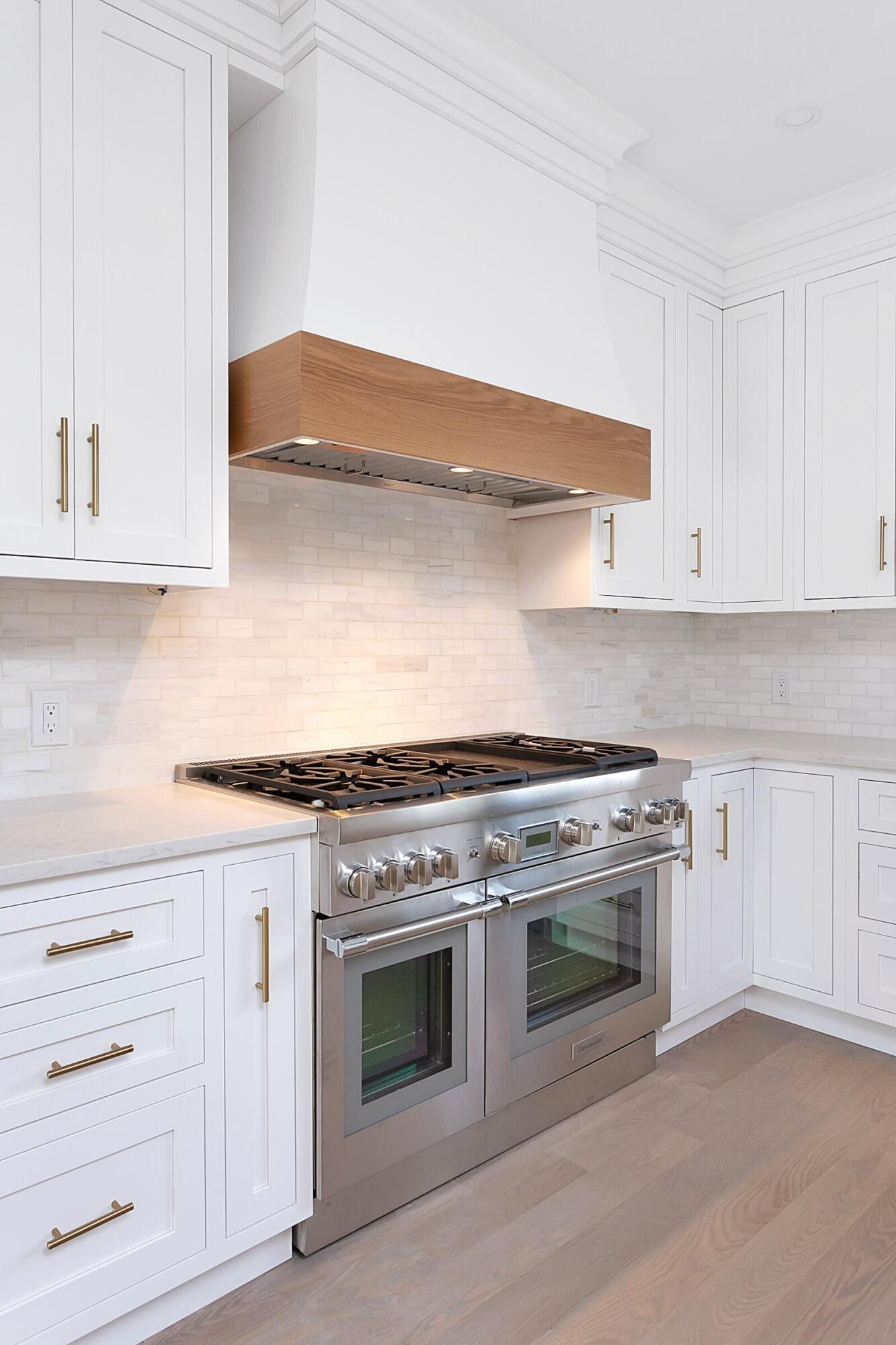 159 Middlesex Road Darien, CT 06820 - Photo 11 of 38 a kitchen with white cabinets and a stove with wooden floors
