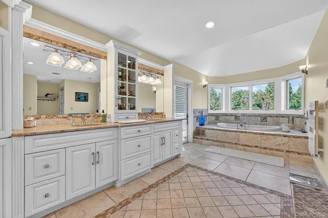 a bathroom with a granite countertop sink and a window