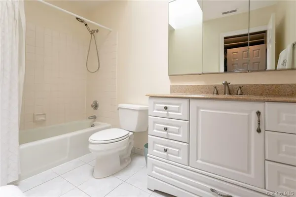 a bathroom with a granite countertop toilet a sink and a bathtub