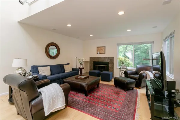 a living room with furniture a fireplace and a large window