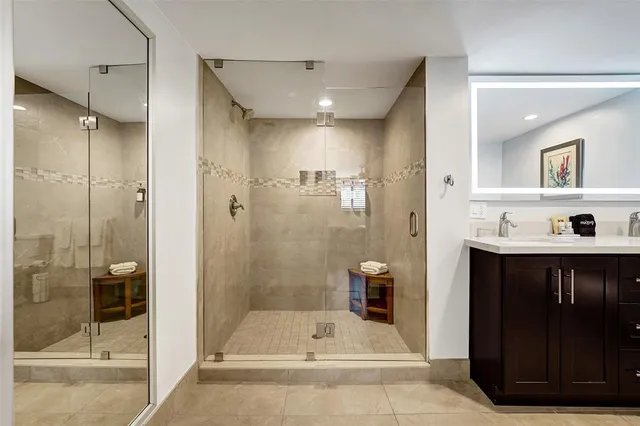 a bathroom with a tub shower vanity and a sink