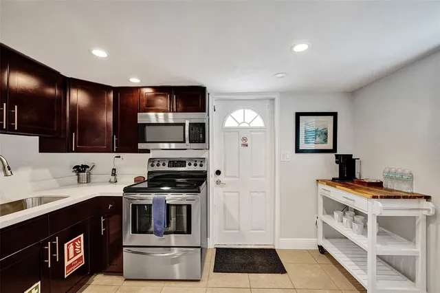 a kitchen with stainless steel appliances kitchen island granite countertop a stove and a sink