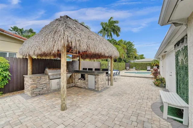 a view of a patio with table and chairs under an umbrella with a fire pit