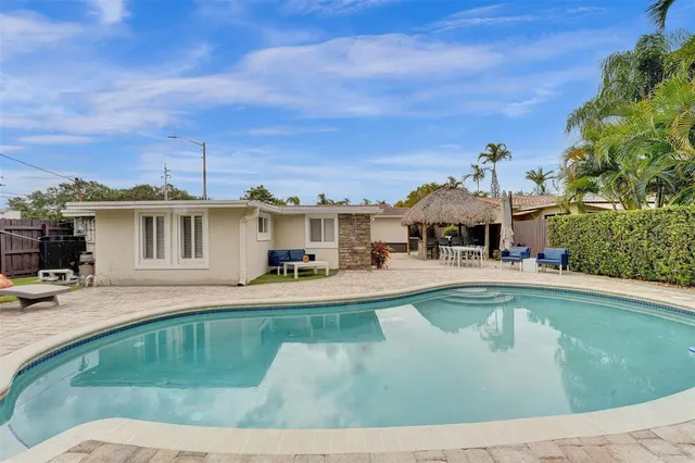 a view of a house with swimming pool and sitting area