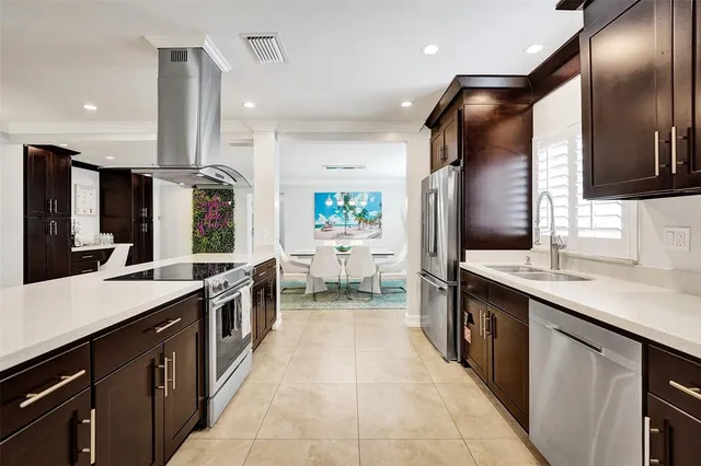 a large kitchen with stainless steel appliances a sink and a refrigerator